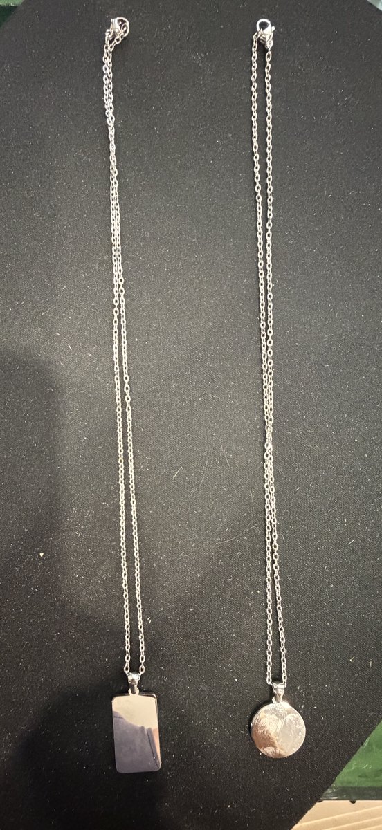 Dos colgantes de acero con su cadena completa: una medalla redonda y una placa rectangular