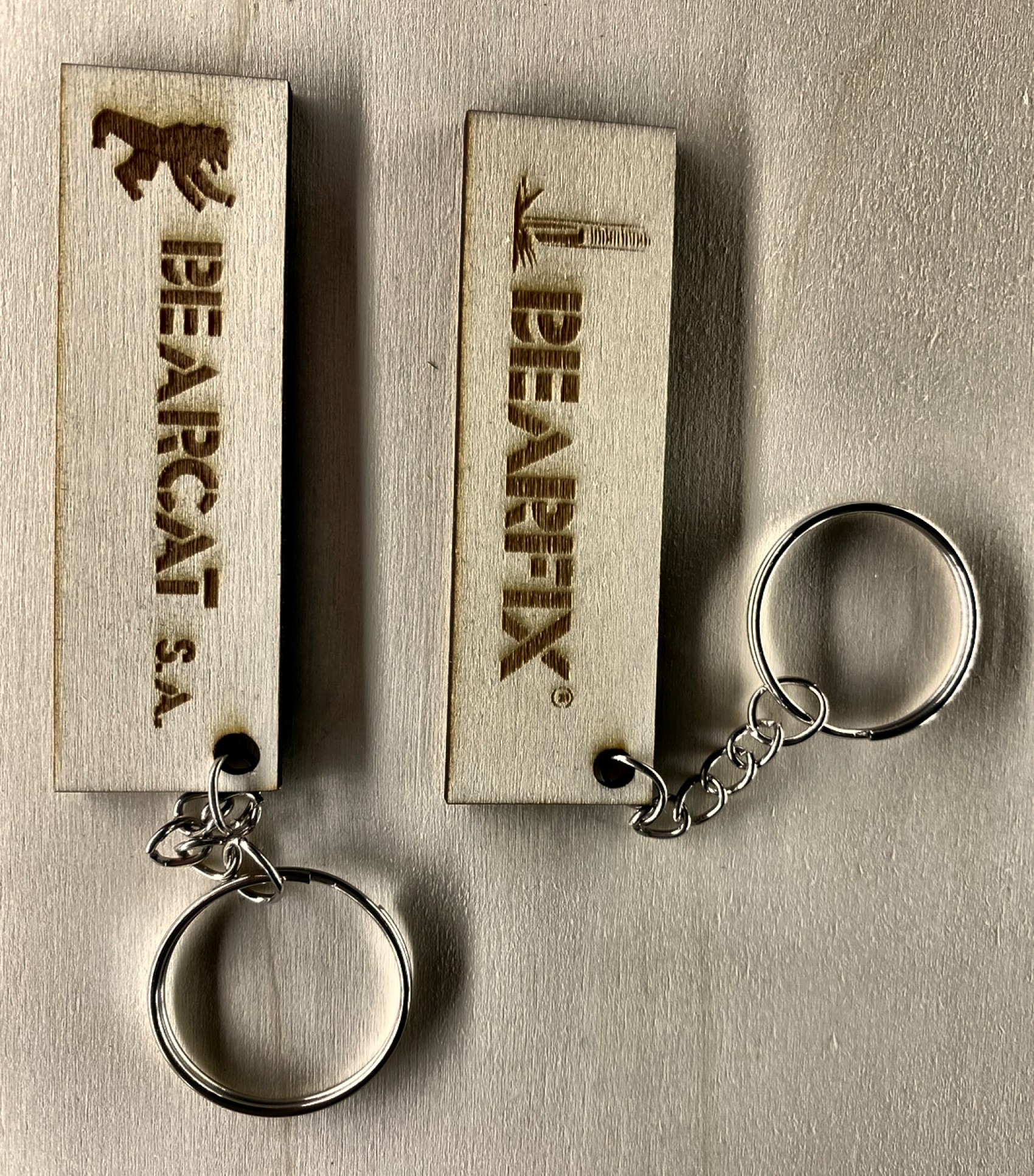 Llaveros de madera con el logo de BEARCAT y BEARFIX grabado